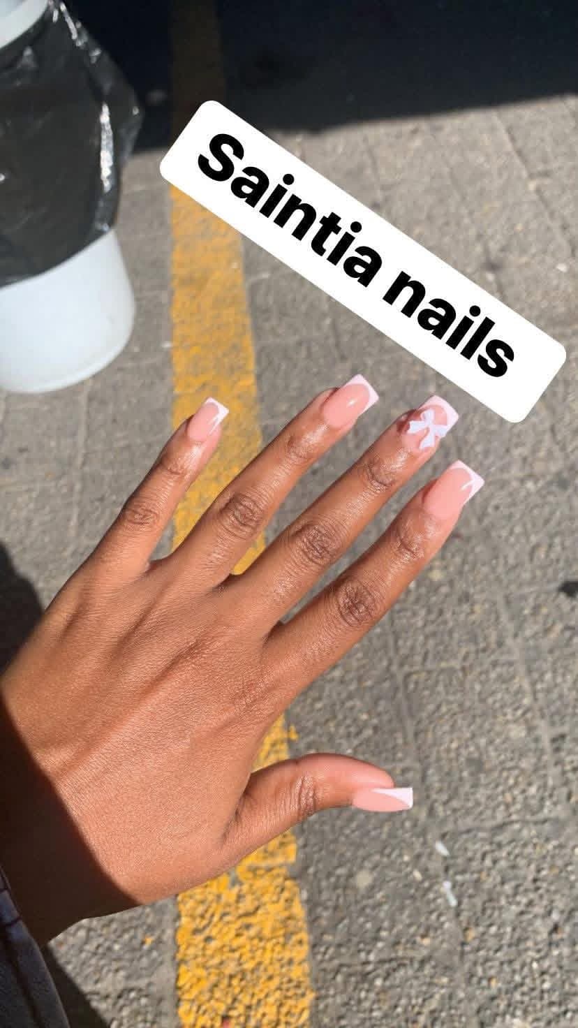 Square nude acrylic nails with soft pink French tips and a white bow accent nail