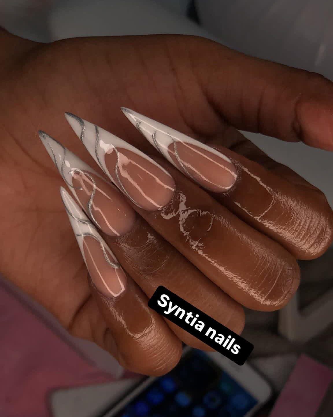 Extra long stiletto nails with white French tips and silver swirl line art