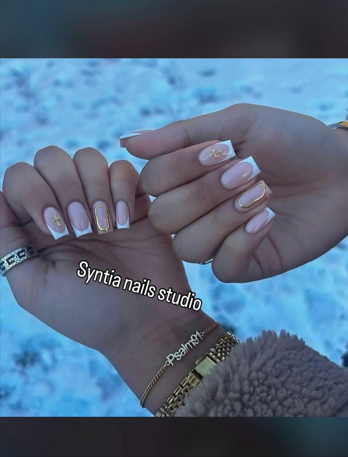 Square white French tip nails with gold cross and gold outline charms