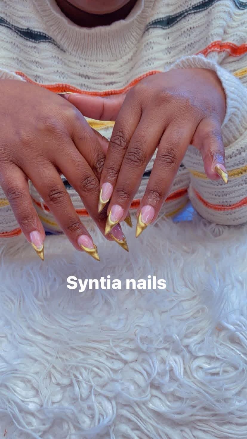 Stiletto nails with nude base and gold chrome French tips