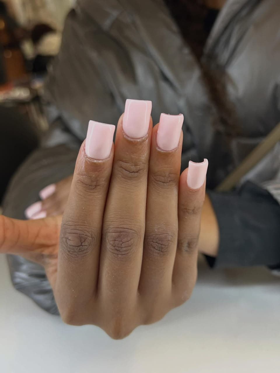 Short square nails in a glossy baby pink gel