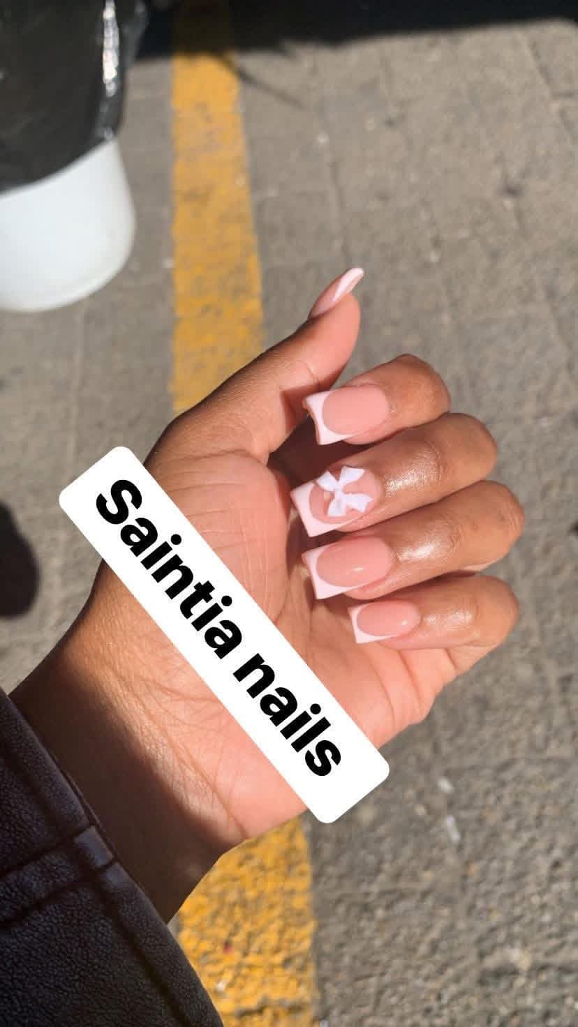 Short square nails with pink French tips and a white bow accent